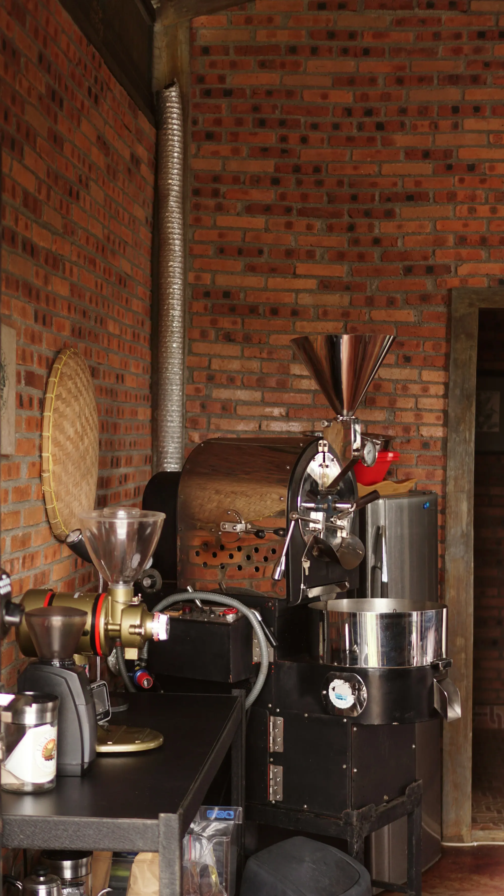 A small drum roaster in a brick roastery