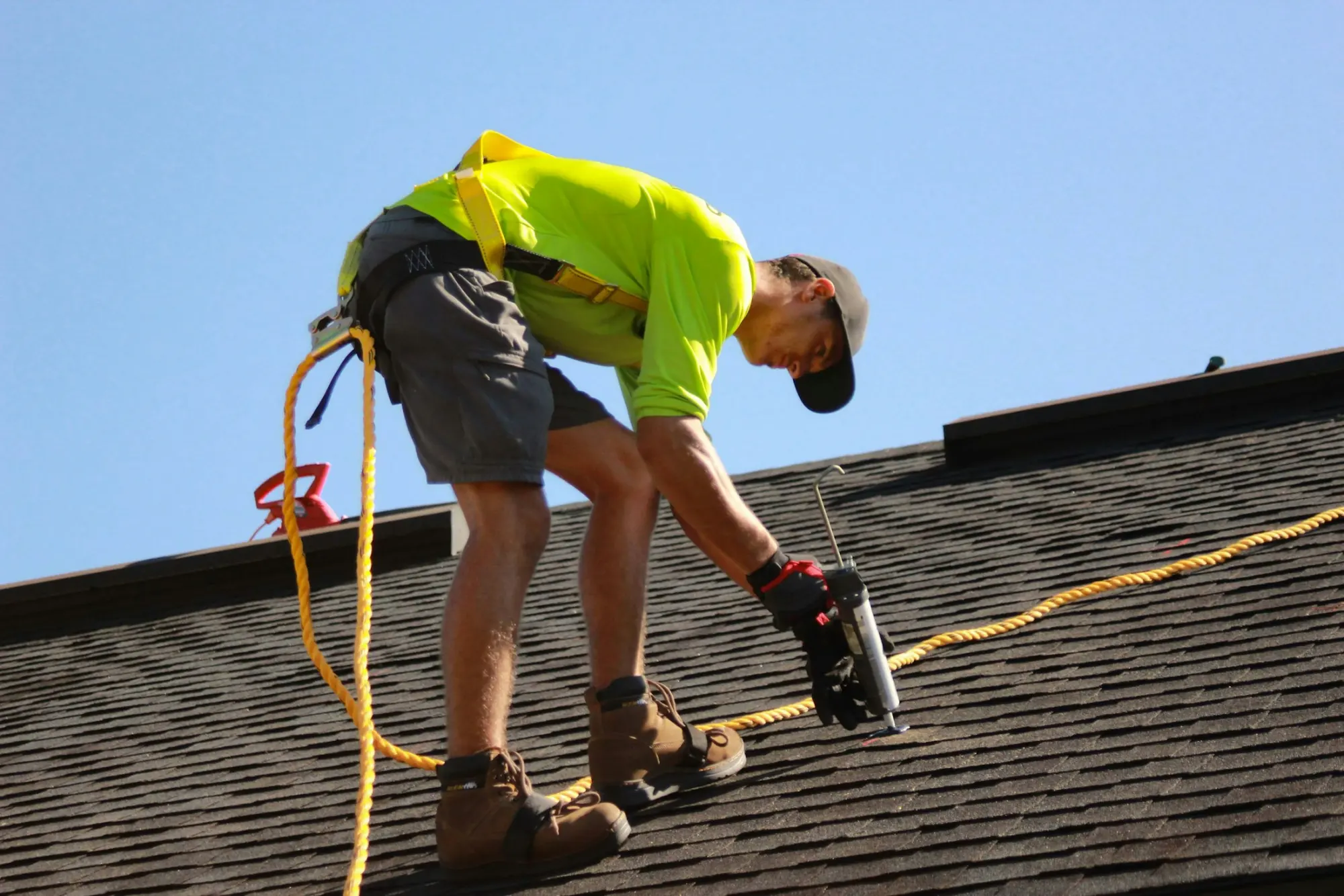 A roofer installing shingles on a sunny day