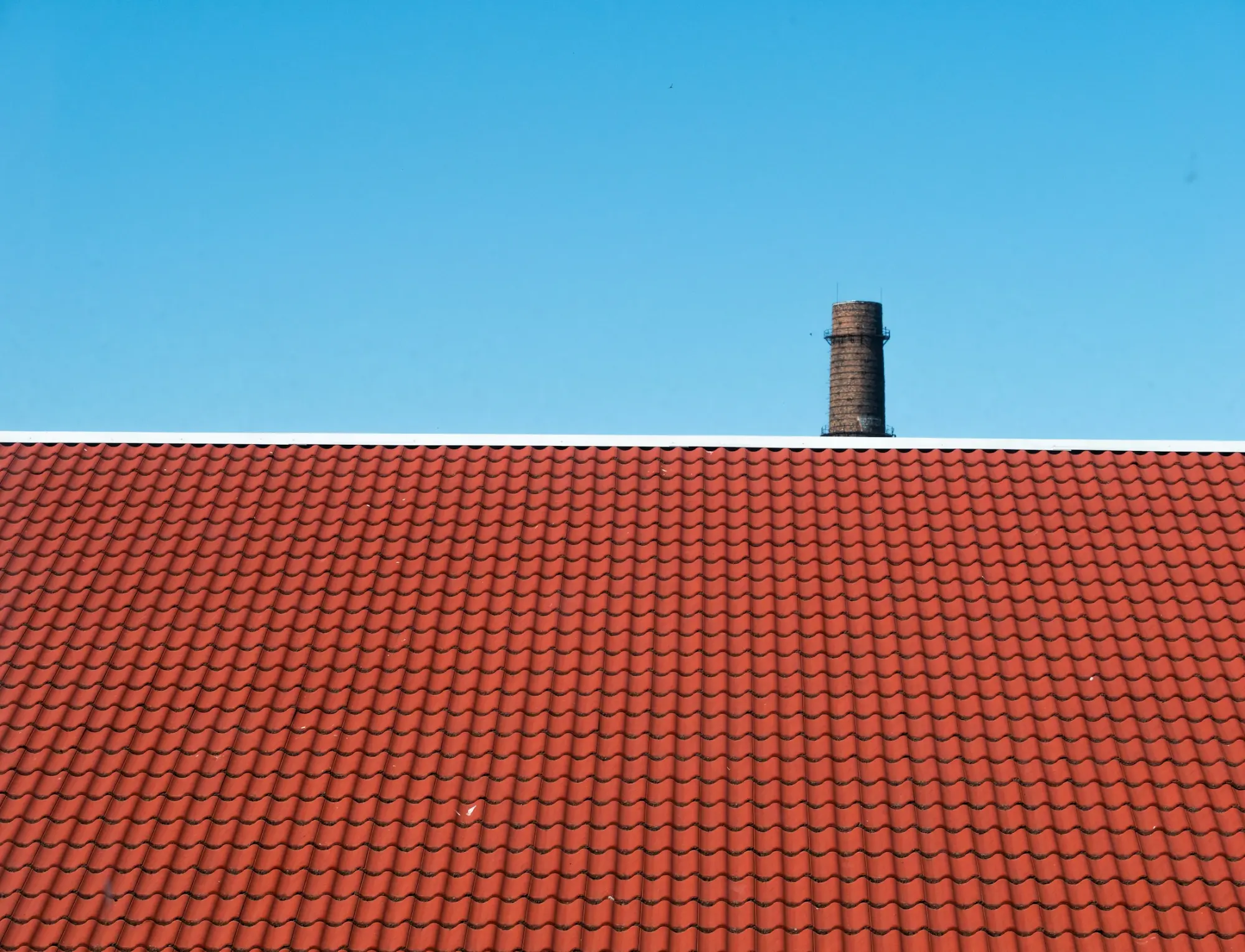 A terracotta tile roof against blue sky